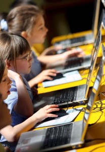 niñas portatil escriben 208x300 La tecnología, las redes sociales y los SMS mejoran la escritura de los niños